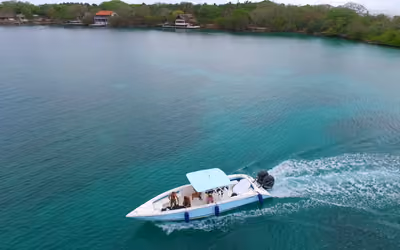Lancha privada con pasajeros navegando en aguas turquesa cerca de Cartagena