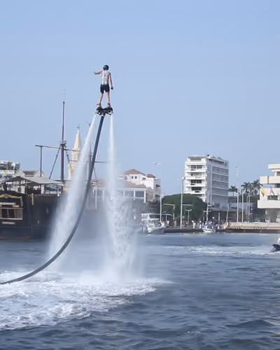 Piloto de Colombia Flyboard elevado sobre la bahía de Cartagena, junto a un galeón
